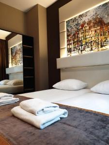 a hotel room with two beds and a mirror at Hotel Mosaic City Centre in Amsterdam