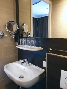 a bathroom with a sink and a mirror at Hotel Mosaic City Centre in Amsterdam