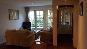 a living room with couches and a sliding glass door at Sneek Vakantiehuis Verhuur in Sneek