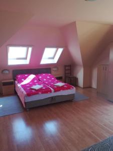 a bedroom with a large bed in a attic at Karika Vendégház in Hajdúszoboszló