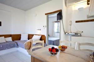 a kitchen and living room with a table with a bowl of fruit at Paros Apartments in Parikia