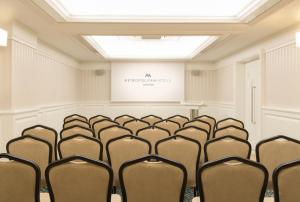 a lecture room with chairs in front of a screen at Metropolitan Hotels Taksim in Istanbul