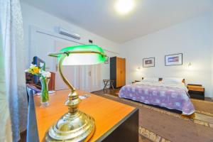 a bedroom with a bed and a lamp on a desk at B&B Sesame Inn in Dubrovnik