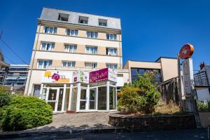 Un gran edificio blanco con un cartel delante. en Hotel Le Boischaut - Citotel Chateauroux, en Châteauroux
