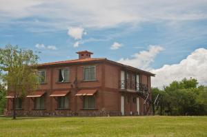 諾諾的住宿－Yerba Buena casas de campo - Arroyo de los Patos，一座大型砖砌建筑,在田野上设有门廊