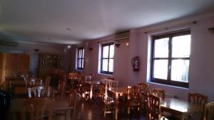 Hospedería Villa de Pintano في Pintano: غرفة طعام مع طاولات وكراسي ونوافذ