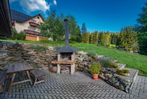 a brick patio with a stone wall and a fireplace at MINERVA in Špindlerův Mlýn