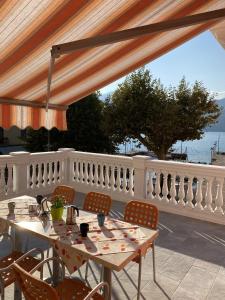 a patio with tables and chairs and a white fence at Casa Balansina in Brenzone sul Garda