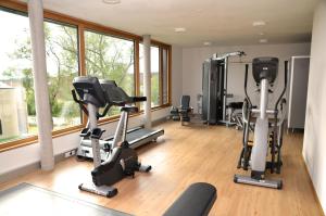 a gym with treadmills and exercise bikes in a room at DEKRA Congresshotel Wart in Altensteig