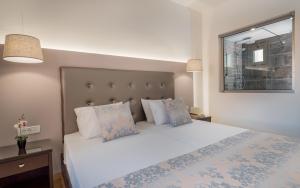 a bedroom with a white bed and a window at Oscar Hotel in Laganas