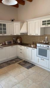 una cucina con armadietti bianchi e piano cottura di villa Rosa a Capitolo