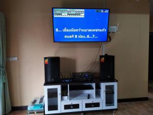 a flat screen tv on top of a tv stand with speakers at 19th house in Ban Nong Sa