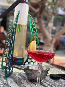 uma bebida vermelha num copo de martini sobre uma mesa em Hotel Internacional Gym & Spa Fushe-Arrez em Fushë-Arrëz