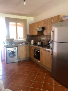 a kitchen with a refrigerator and a washing machine at Brand new Beautiful Vacation house - Family Only in Cabo Negro