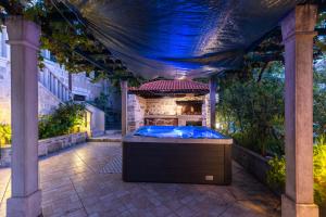 a hot tub in a backyard with a pergola at Seafront vacation house w JACUZZI 5 meters from beach in Sumartin