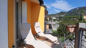 einen Balkon mit weißen Stühlen auf einem Gebäude in der Unterkunft Arco Charme in Arco