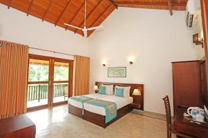 a bedroom with a bed and a balcony at Villa Peacock in Galle