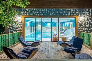 a patio with lounge chairs and a swimming pool at Villa Źródło & Spa in Krynica Zdrój