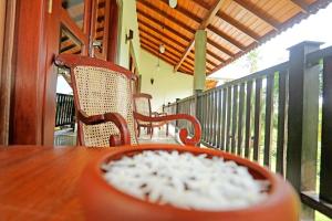a wooden table with chairs on a porch at Villa Peacock in Galle