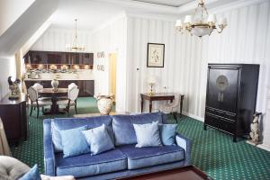 a living room with a blue couch and a table at Grumant Resort & Spa in Yasnaya Polyana