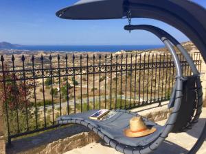 a hat sitting on a bench overlooking the ocean at Villa Asteri, views, private, pool heating on request, 30 mins from Paphos in Paphos