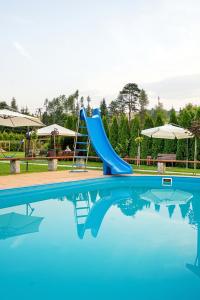 a blue slide in a swimming pool at Villa Źródło & Spa in Krynica Zdrój