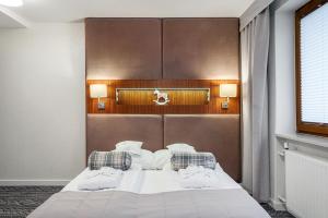 クリニツァ・ズドルイにあるVilla Źródło & Spaのベッドルーム1室(白いシーツと枕のベッド1台付)