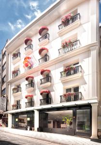 biały budynek z czerwonymi balkonami przy ulicy w obiekcie Last Vita w Stambule