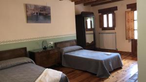 a bedroom with two beds and a dresser in it at MASIA MAS DE LA CREU in Valderrobres