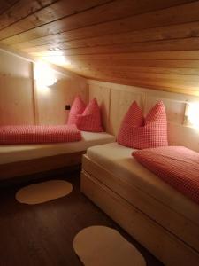 a room with two beds in a wooden cabin at Tanterhütte by Tanterhof in Schwendau