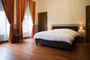 a bedroom with a bed and a large window at Castle ten Berghe Château in Bruges