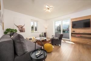 a living room with a couch and a flat screen tv at Seelos - Alpine Easy Flats in Mieming