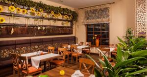 a restaurant with tables and chairs and flowers on the wall at Confero in Nysa