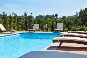 - une piscine avec des chaises longues et une table dans l'établissement Quinta do Lordelo Turismo Rural, à Penafiel