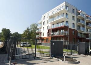 a building with a gate in front of a building at Apartament Polanki in Kołobrzeg