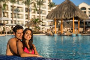 Ein Mann und eine Frau sitzen im Pool in der Unterkunft Hyatt Ziva Los Cabos - All Inclusive in San José del Cabo