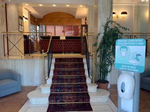 un vestíbulo con escaleras con un cartel delante en Hotel Continental en Turín