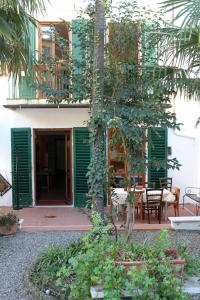 een gebouw met groene luiken en een tafel en stoelen bij Apartment ninnananna in Florence