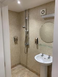a bathroom with a sink and a shower with a mirror at The Olive in Market Rasen
