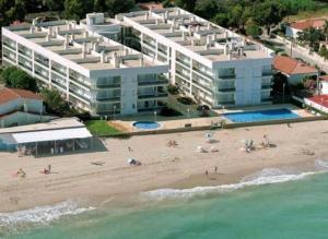 eine Luftansicht auf einen Strand mit Menschen und Gebäuden in der Unterkunft Apartamento con Vitas al Mar in Miami Platja
