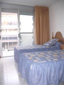 1 Schlafzimmer mit 2 Betten und einem großen Fenster in der Unterkunft Apartamento con Vitas al Mar in Miami Platja