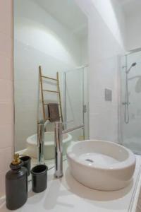 ein weißes Badezimmer mit einem Waschbecken und einem Spiegel in der Unterkunft Sweety Balcony Porto Center in Porto