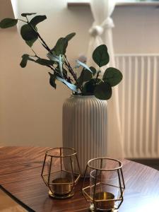 a vase with a plant and three candles on a table at MILPAU Buer in Gelsenkirchen