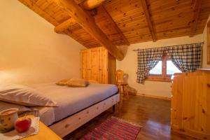 a bedroom with a bed and a wooden ceiling at Appartamento Paola in Livigno