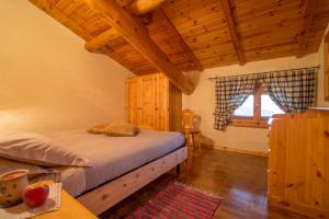 ein Schlafzimmer mit einem Bett und einer Holzdecke in der Unterkunft Appartamento Paola in Livigno
