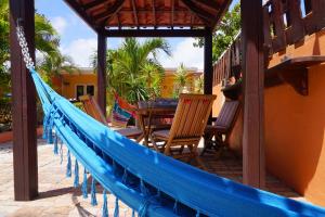 a hammock on a porch with chairs and a table at Cariñas Studio Apartments in Palm-Eagle Beach