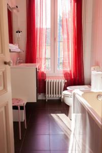 bagno con tende rosse, servizi igienici e lavandino di Hôtel du Parc a Choisy-le-Roi