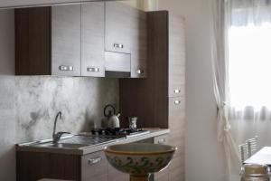 a kitchen with a sink and a stove top oven at B&B Al Cortile del Bertolet in Pian Camuno