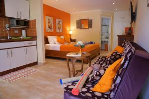 鷹海灘的住宿－Cariñas Studio Apartments，带沙发和床的客厅以及厨房。