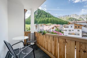 a balcony with a table and chairs and a view at Hotel Nevada in Samnaun